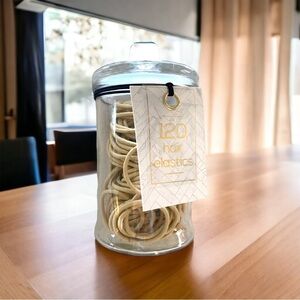 A glass jar of hair elastics new
